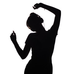 silhouette of a girl listening to music in headphones, figure of woman relaxing on a white isolated background
