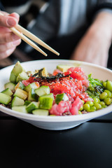 Woman eating hawaiian poke bowl