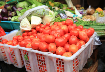 Red tomato in basket selling at traditional market at countryside