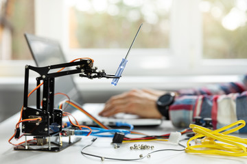 robotics engineer programming robot arm in office