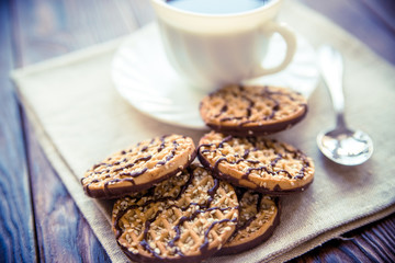 Coffee with biscuits on brown wooden background 