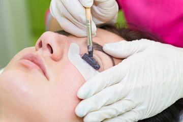 Woman on the procedure for eyelash extensions, eyelashes lamination 