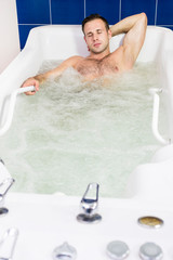 The young man is the procedure in the whirlpool hydrobath 