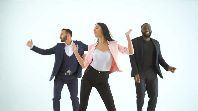 The Three People Dancing On The White Background. Slow Motion