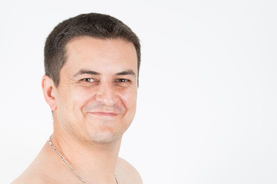 smiling portrait of a young handsome man shirtless with a white background