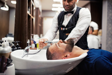 Hipster man client visiting haidresser and hairstylist in barber shop.