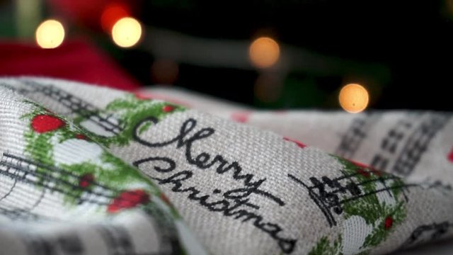 Merry Christmas text on a kitchen cloth apron in front of a Christmas Tree