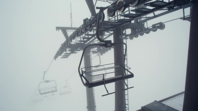 Active Empty Chairlift with No People in Winter. Nobody Using Abandoned Ski Elevator in Fog. Monochrome Apocalyptic Sad Shot