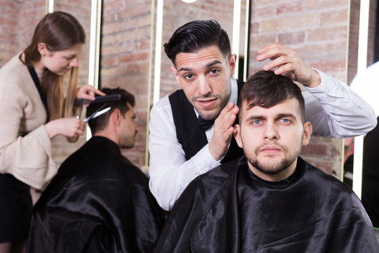 Hairdresser discussing hairstyling with male client