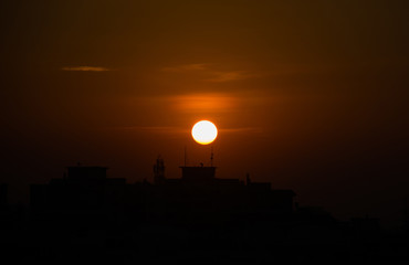 Fototapeta premium Sunrise against urban skyline