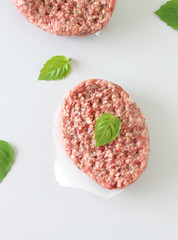 fresh cutlet and basil leaves on a light background