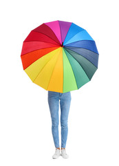 Woman hiding behind rainbow umbrella on white background