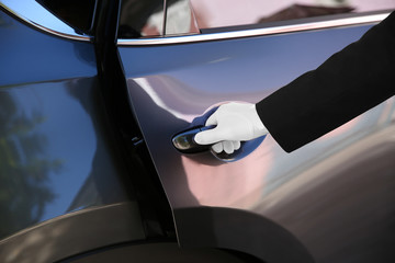 Naklejka premium Driver opening car door, closeup. Chauffeur service