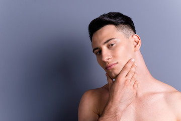Close up portrait of brunet brutal man touch cheek look at camer