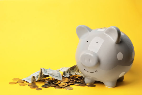 Piggy bank with money on color background. Space for text