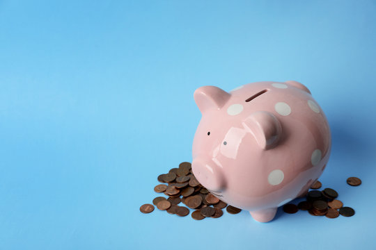Cute piggy bank and coins on color background. Space for text