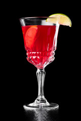 beautiful red cocktail in a beautiful glass isolated on a black background. close up. dark background.