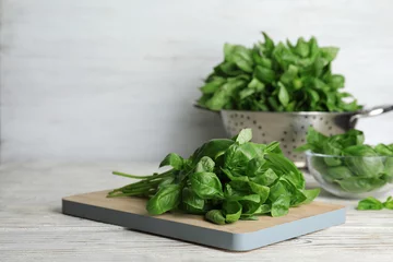 Photo sur Plexiglas Herbes Wooden board with basil leaves on table. Space for text