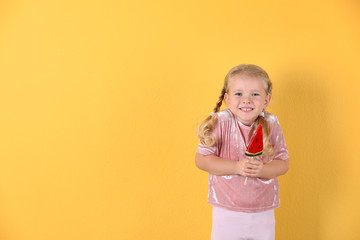 Cute little girl with candy on color background. Space for text
