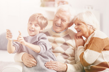 Happy seniors posing for a photo with their teenage grandson