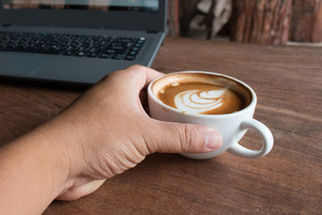 Close up of Cup of hot latte art coffee on wooden table