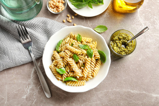 Plate of delicious basil pesto pasta served for dinner on table, flat lay