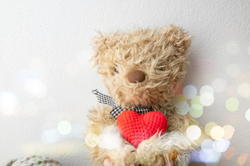 Fototapeta premium Teddy bear holding a heart-shaped pillow with plank wood on white background , concept valentine