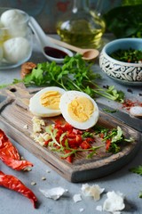 The process of cooking boiled marinated chicken eggs with vegetables, herbs, spices and tomato sauce.