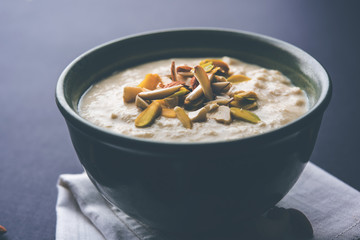 Sweet Rabdi or Lachha Rabri or basundi, made with pure milk garnished with dry fruits. Served in a bowl over moody background. Selective focus
