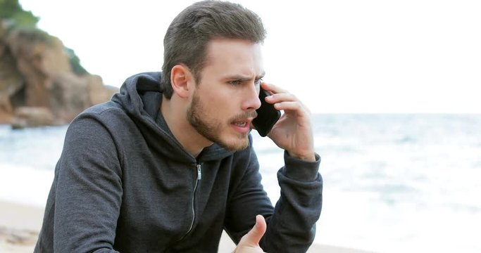 Angry man calling on phone claiming to customer service on the beach