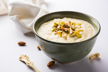 Sweet Rabdi or Lachha Rabri or basundi, made with pure milk garnished with dry fruits. Served in a bowl over moody background. Selective focus