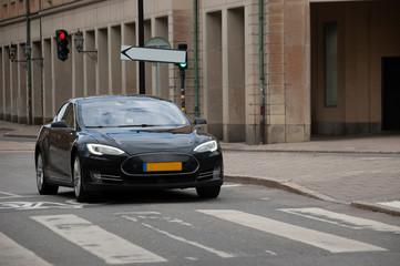 Fototapeta na wymiar Modern electric car on the street of the old beautiful city.