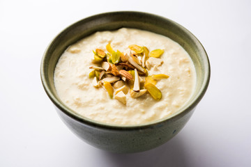 Sweet Rabdi or Lachha Rabri or basundi, made with pure milk garnished with dry fruits. Served in a bowl over moody background. Selective focus