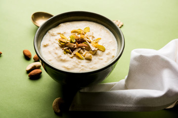 Sweet Rabdi or Lachha Rabri or basundi, made with pure milk garnished with dry fruits. Served in a bowl over moody background. Selective focus