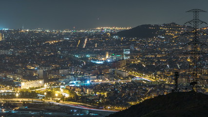 Barcelona and Badalona skyline with roofs of houses and sea on the horizon night timelapse