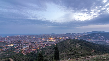 Obraz premium Barcelona and Badalona skyline with roofs of houses and sea on the horizon day to night timelapse