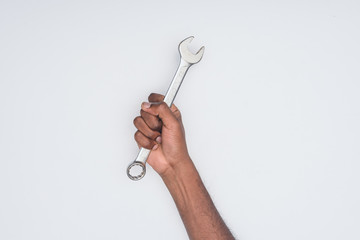 cropped shot of african american man holding wrench isolated on white