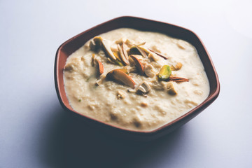 Sweet Rabdi or Lachha Rabri or basundi, made with pure milk garnished with dry fruits. Served in a bowl over moody background. Selective focus