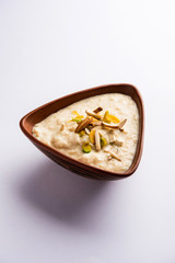 Sweet Rabdi or Lachha Rabri or basundi, made with pure milk garnished with dry fruits. Served in a bowl over moody background. Selective focus