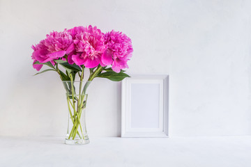 Mockup with a white frame and pink peonies