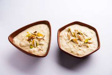 Sweet Rabdi or Lachha Rabri or basundi, made with pure milk garnished with dry fruits. Served in a bowl over moody background. Selective focus