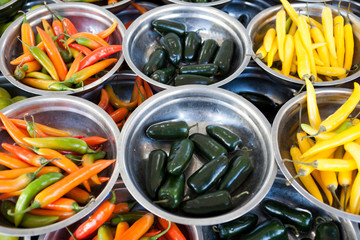 Hot peppers different varieties is on the plates on the counter market. Chile pepper, Cayenne...