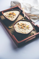 Sweet Rabdi or Lachha Rabri or basundi, made with pure milk garnished with dry fruits. Served in a bowl over moody background. Selective focus