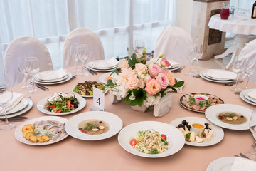 Served for banquet restaurant table with dishes, snack, cutlery, wine and water glasses, european food, selective focus