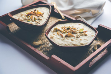 Sweet Rabdi or Lachha Rabri or basundi, made with pure milk garnished with dry fruits. Served in a bowl over moody background. Selective focus