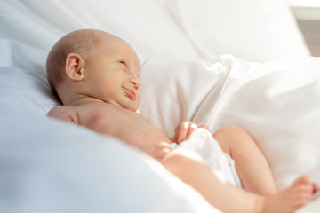 Newborn baby girl lying in a white sheet