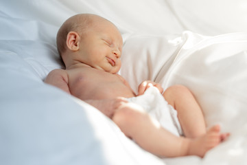 Newborn baby girl lying in a white sheet