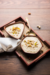 Sweet Rabdi or Lachha Rabri or basundi, made with pure milk garnished with dry fruits. Served in a bowl over moody background. Selective focus