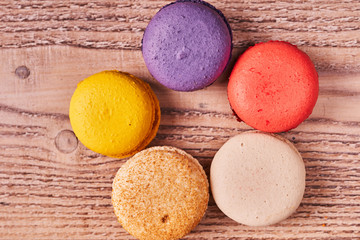 Cake macaron or macaroon on wooden background from above, colorful almond cookies, top view
