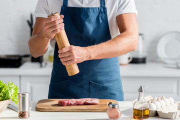 cropped view of man seasoning meat for the dinner